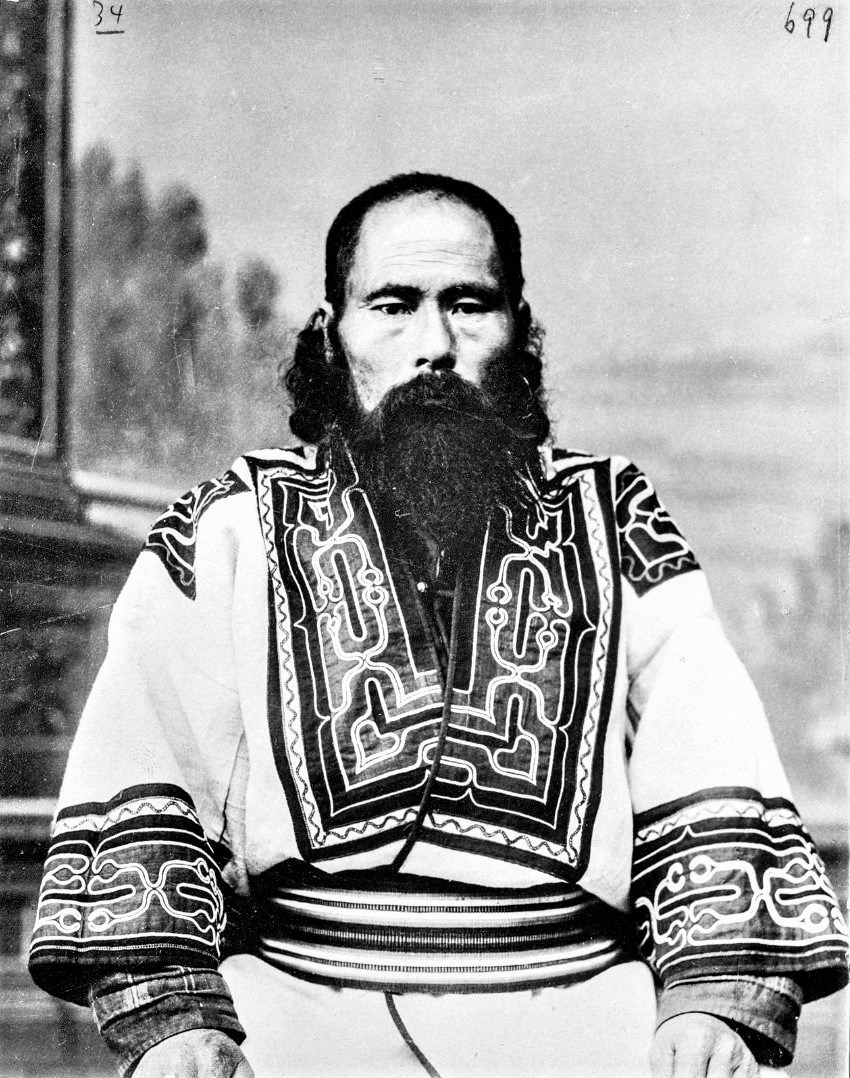 A Sakhalin Ainu man in a traditional appliqué robe, photographed c. 1905